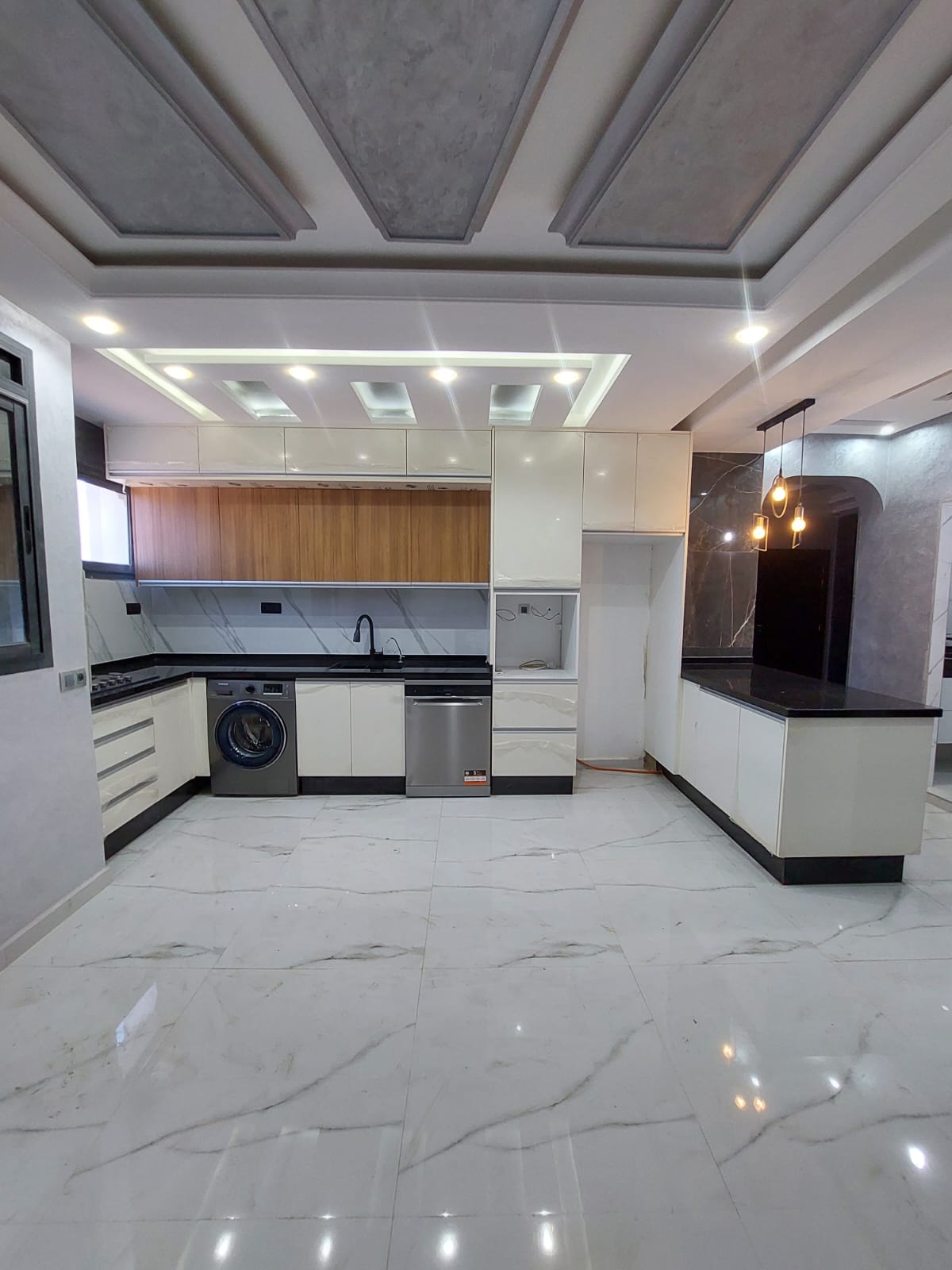 Cuisine ouverte blanche et bois avec faux plafond et éclairage décoratif